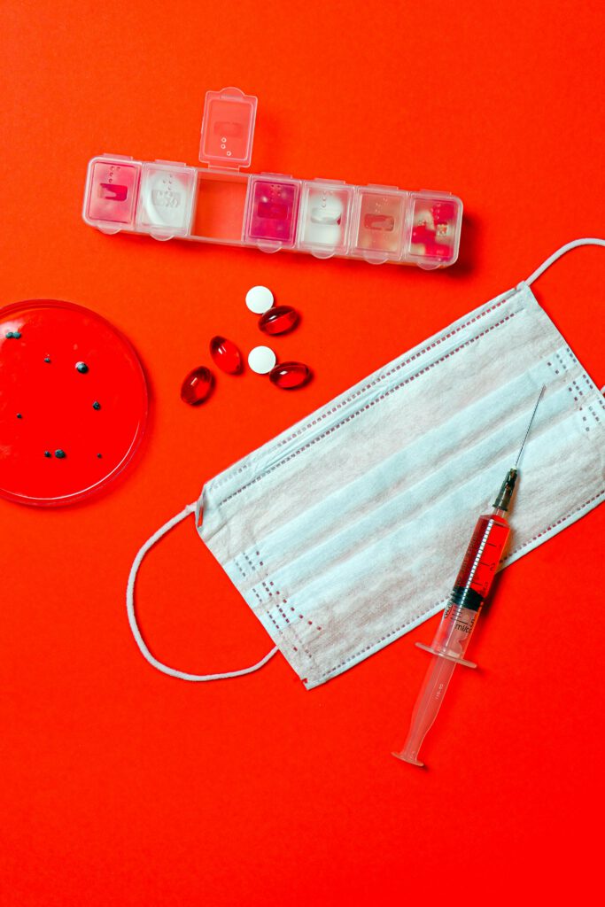 Here is another image of medical supplies like a protective mask, medicine, pill container, and a syringe.